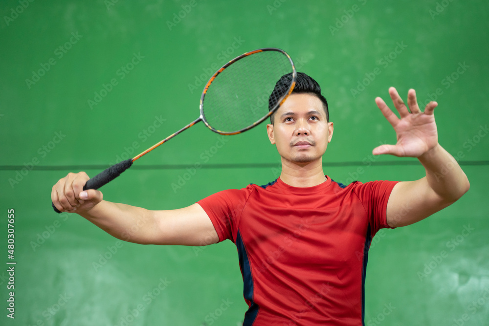 Asian male badminton player ready to receive the shuttlecock
