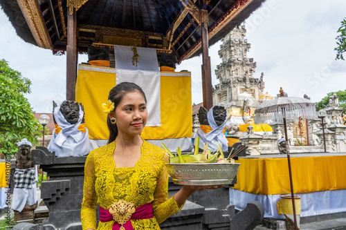 Tablou pe pânză Balinese girl worshipping at a temple