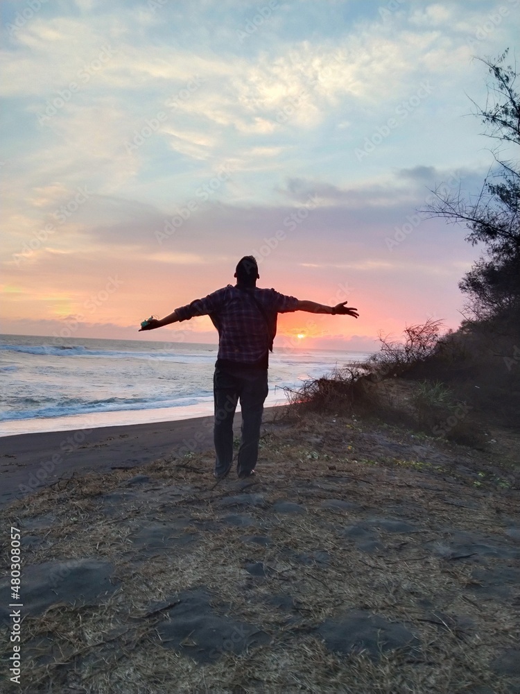 Fototapeta premium person on the beach at sunset