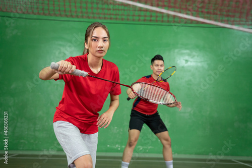 Beautiful badminton player looking at camera with a ready stance