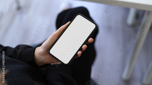 A modern smartphone blank screen mockup in a woman's hand.
