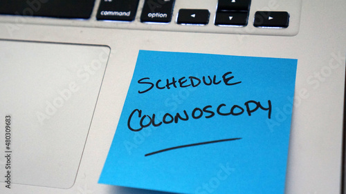 Sticky note reminder to schedule colonoscopy, an important screening for colorectal cancer.