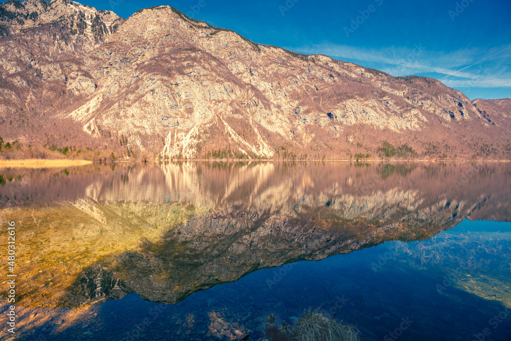 Mountain lake with beautiful reflection. Lake Bohinj in early spring. Triglav national park, Slovenia