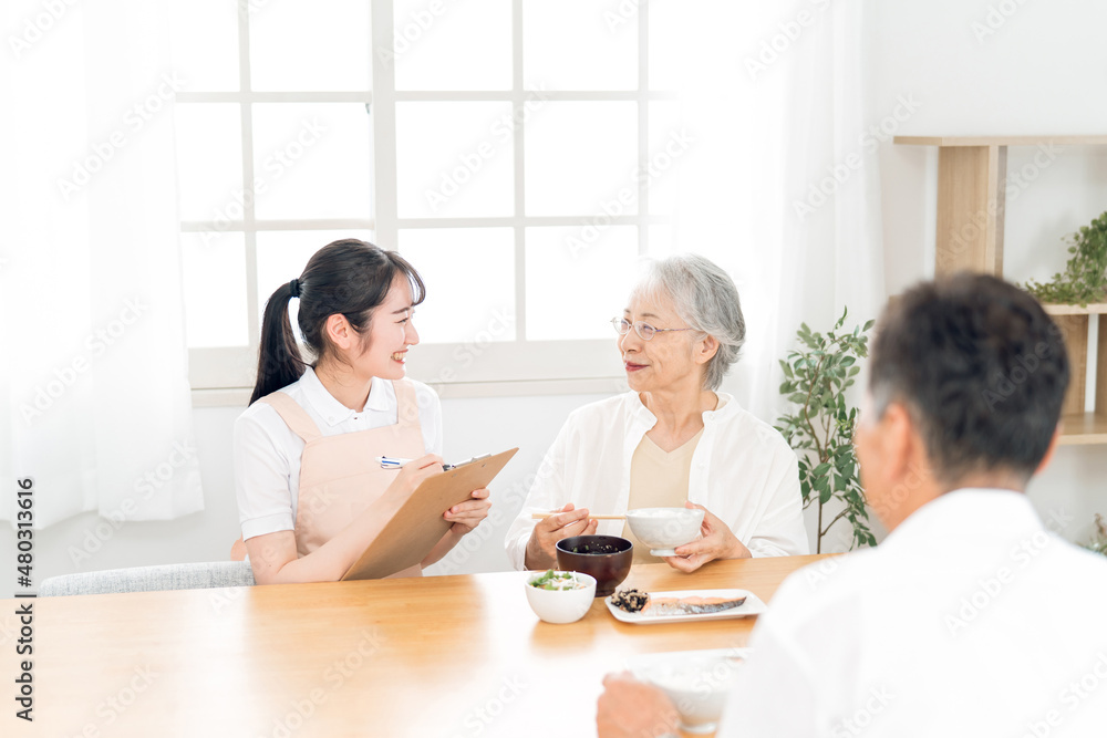 高齢者の食事をチェックする女性（栄養士）
