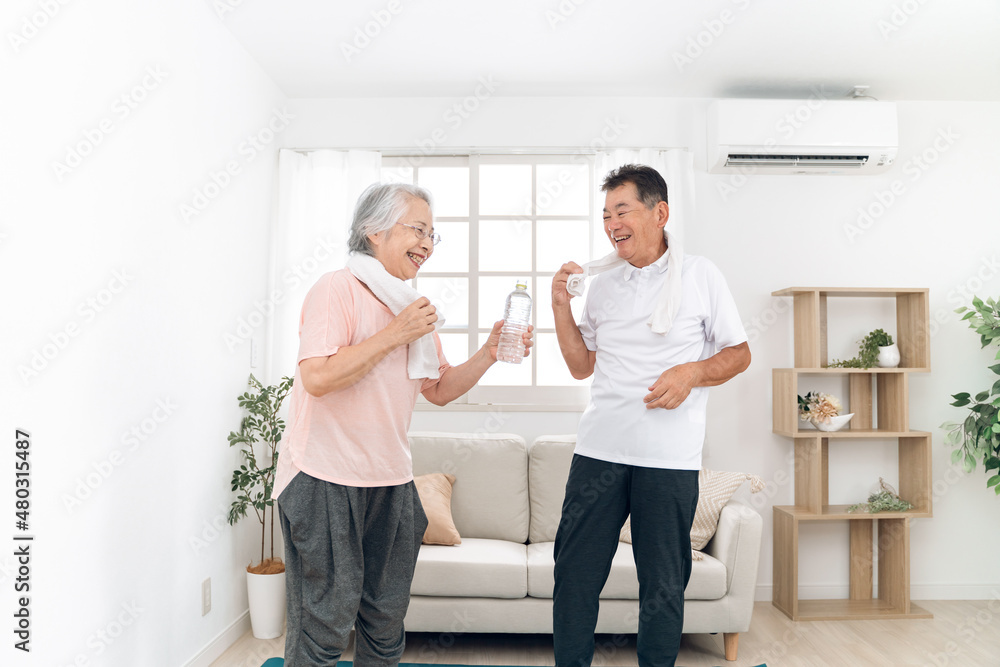 家で運動する高齢者の男女（汗・笑顔）
