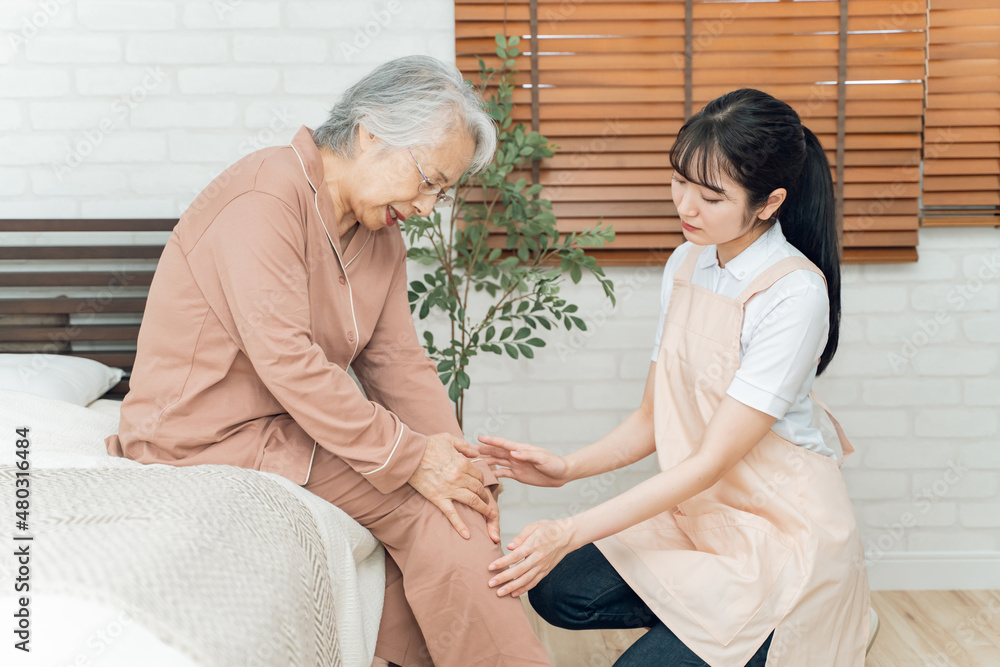 Fototapeta premium 痛がる高齢者女性と介護士の女性（膝痛）