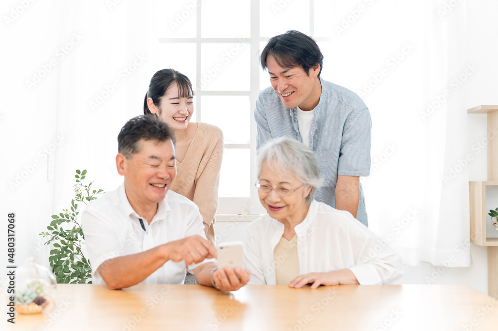 スマホを見る家族（笑顔）
