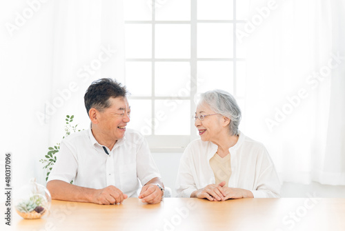 テーブルに座る高齢者夫婦（話す）
 photo