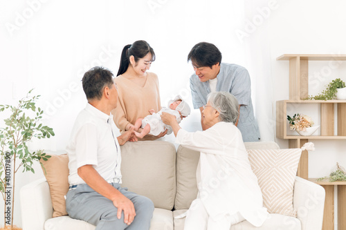 赤ちゃんを抱いた若い夫婦と老夫婦（里帰り）
