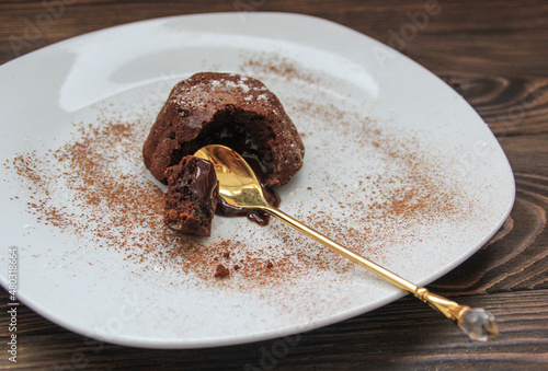  Hot chocolate dessert lava cake with cream and small spoon, close-up