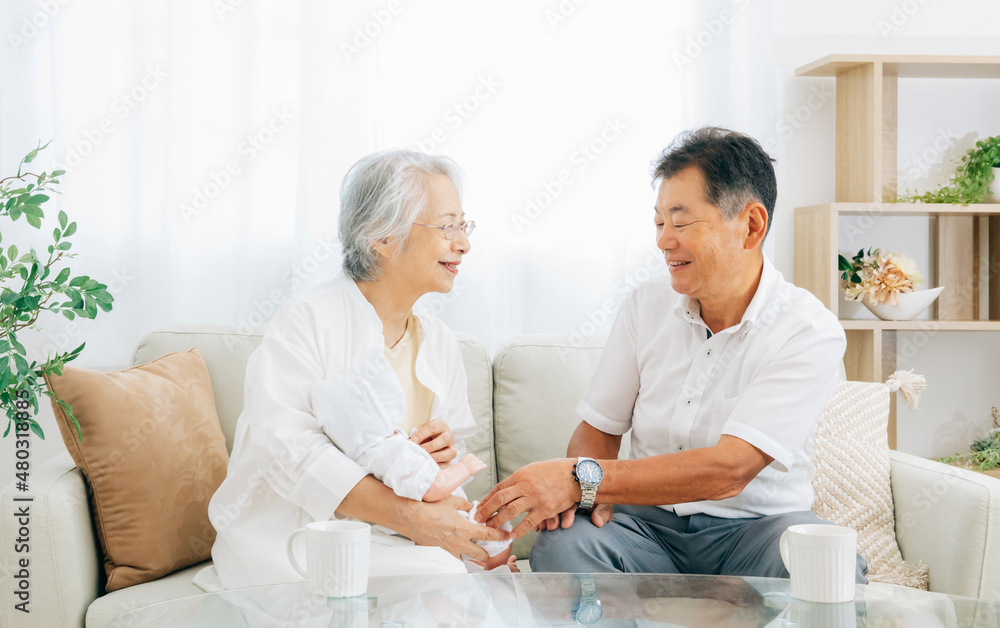 Obraz premium 孫を抱く高齢者女性と男性