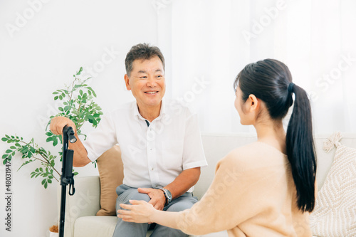 高齢者の男性と若い女性（介護・笑顔） 