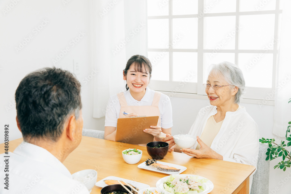 高齢者の食事をチェックする女性（栄養士）
