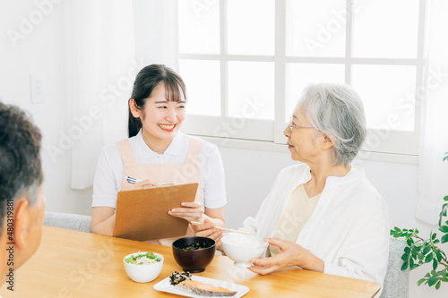 高齢者の食事をチェックする女性（栄養士） 