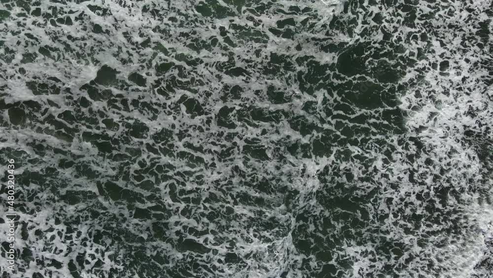 Birds eye view of calm ocean white cap waves with sea foam Birds eye view of calm ocean white cap waves with sea foam