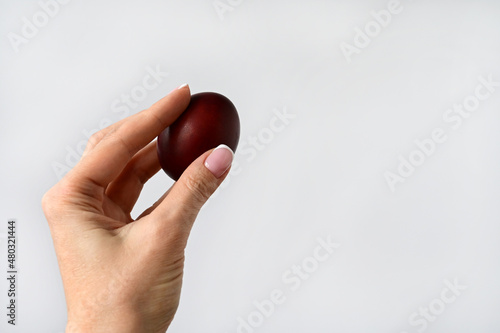 woman's hand holds an Easter colored egg isolated on a white background. Space for text