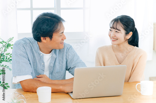 ノートパソコンを見る夫婦（笑顔）  © buritora