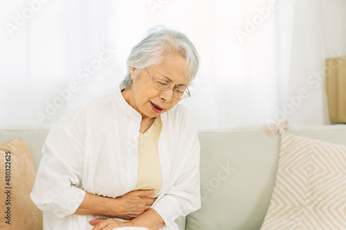 お腹が痛い高齢者女性  © buritora