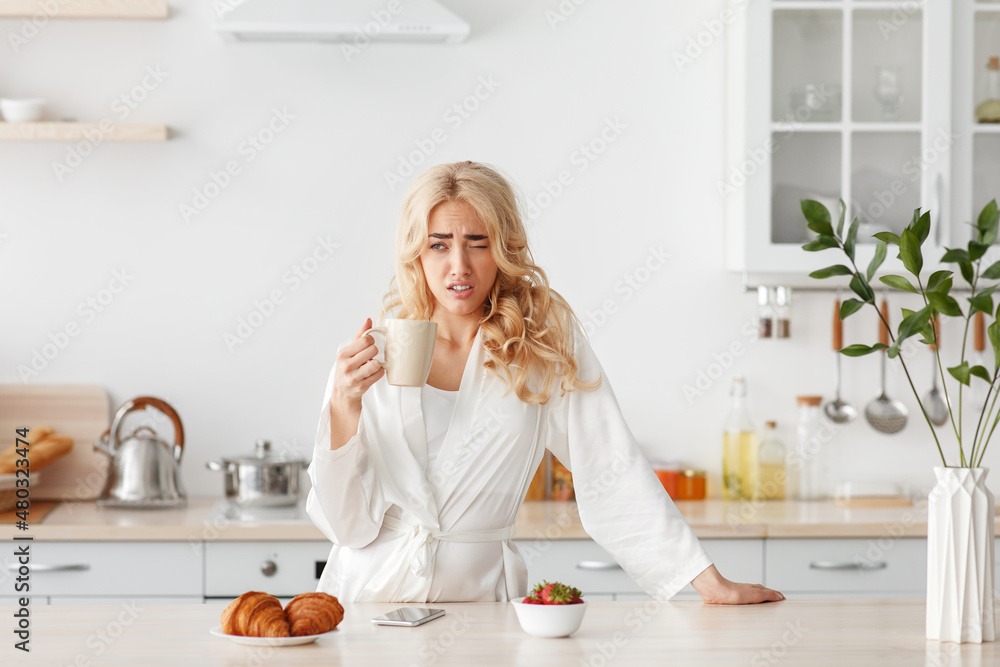 Tired sleepy woman eating breakfast alone, facial emotions, insomnia and sleeping disorder Tired sleepy woman eating breakfast alone, facial emotions, insomnia and sleeping disorder