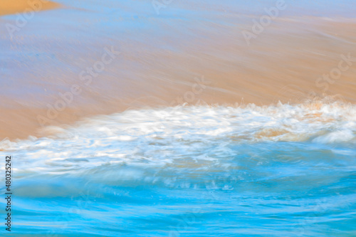 Abstract blurred patterns of a Pacific ocean wave at the beach in a famous tourist destination, Seal Beach in California, USA, long exposure
