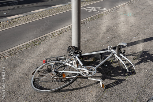 Bicycle tied to a street pole with stolen parts and missing front wheel, Prenzlauer Berg district in Berlin, Germany.