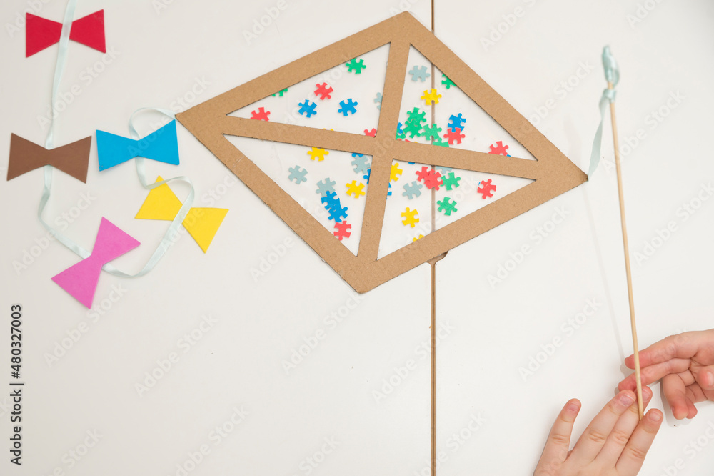 The Child Is Creating A Kite. The Detail Of The Puzzle Is A Symbol Of  Autism.