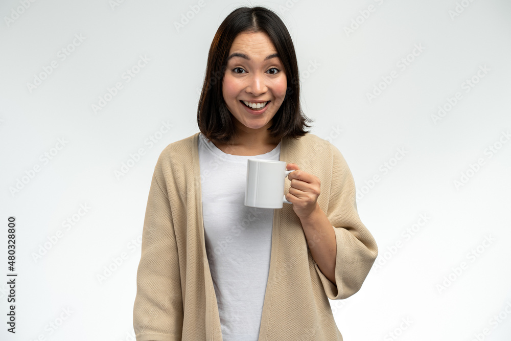 Delighted young asian ethnic woman in domestic wear smiling and looking at camera Delighted young asian ethnic woman in domestic wear smiling and looking at camera