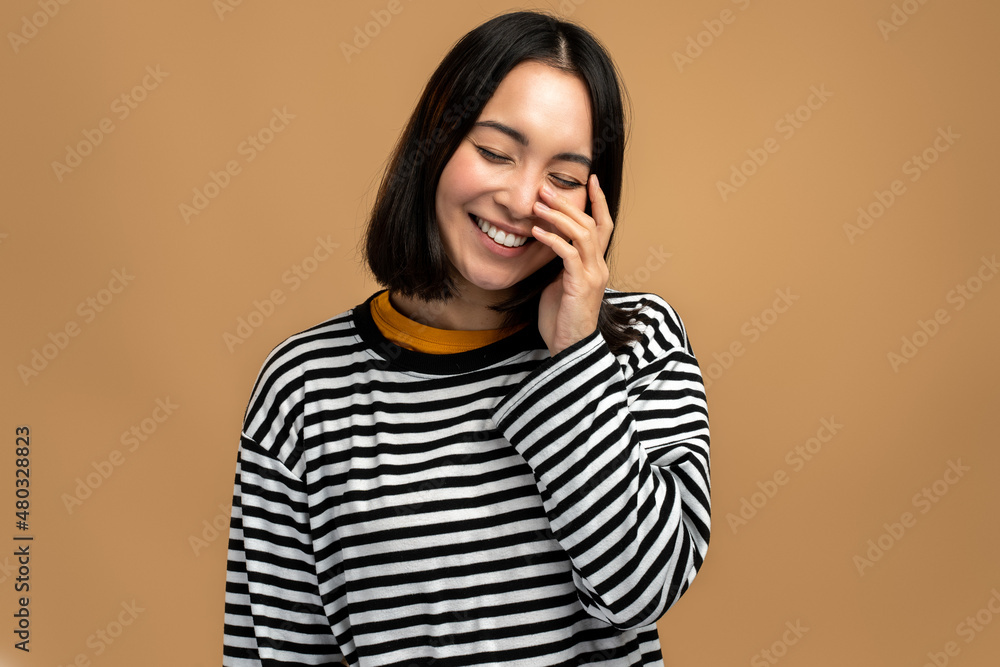 Amusing joyous young woman closing eyes, pointing finger and laughing out loud at funny joke Amusing joyous young woman closing eyes, pointing finger and laughing out loud at funny joke