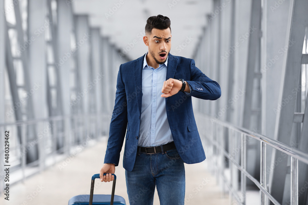 Late To Flight. Worried Arab Man Checking Time On Wristwatch At Airport Late To Flight. Worried Arab Man Checking Time On Wristwatch At Airport