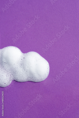 Cosmetic smears and drops. Appearance of the texture the foam on purple background. Natural skincare products. Beauty concept for face and body care