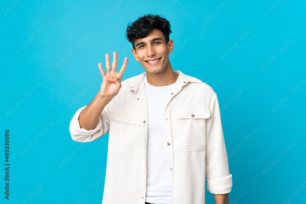 Young Argentinian man isolated on background happy and counting four with fingers Young Argentinian man isolated on background happy and counting four with fingers