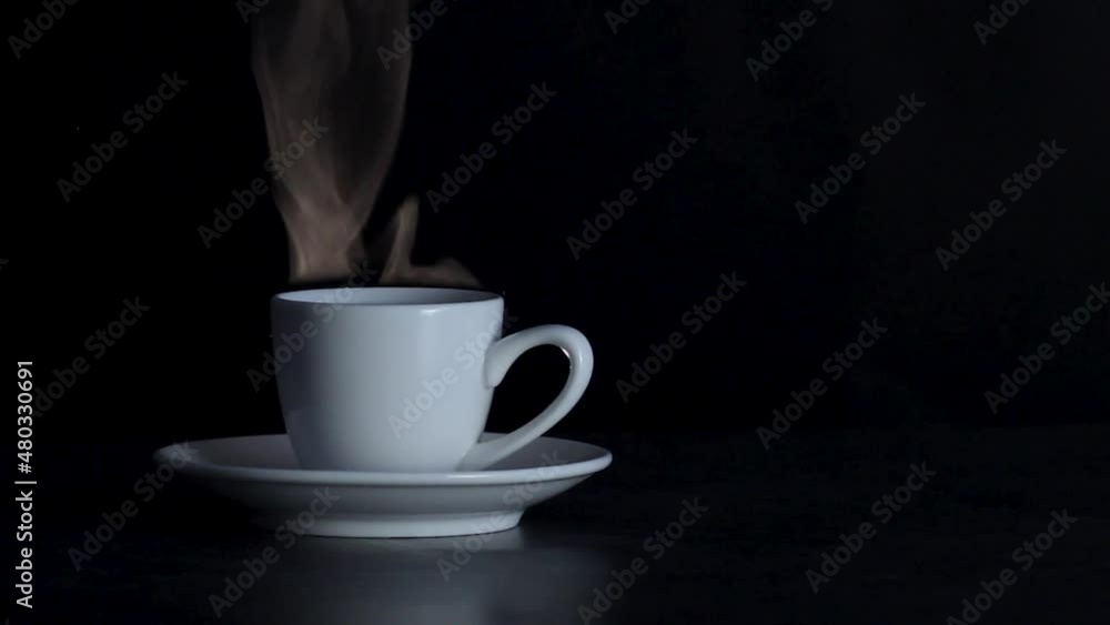 Cup with a hot coffee in black background. Steam from coffee. Cup with a hot coffee in black background. Steam from coffee.