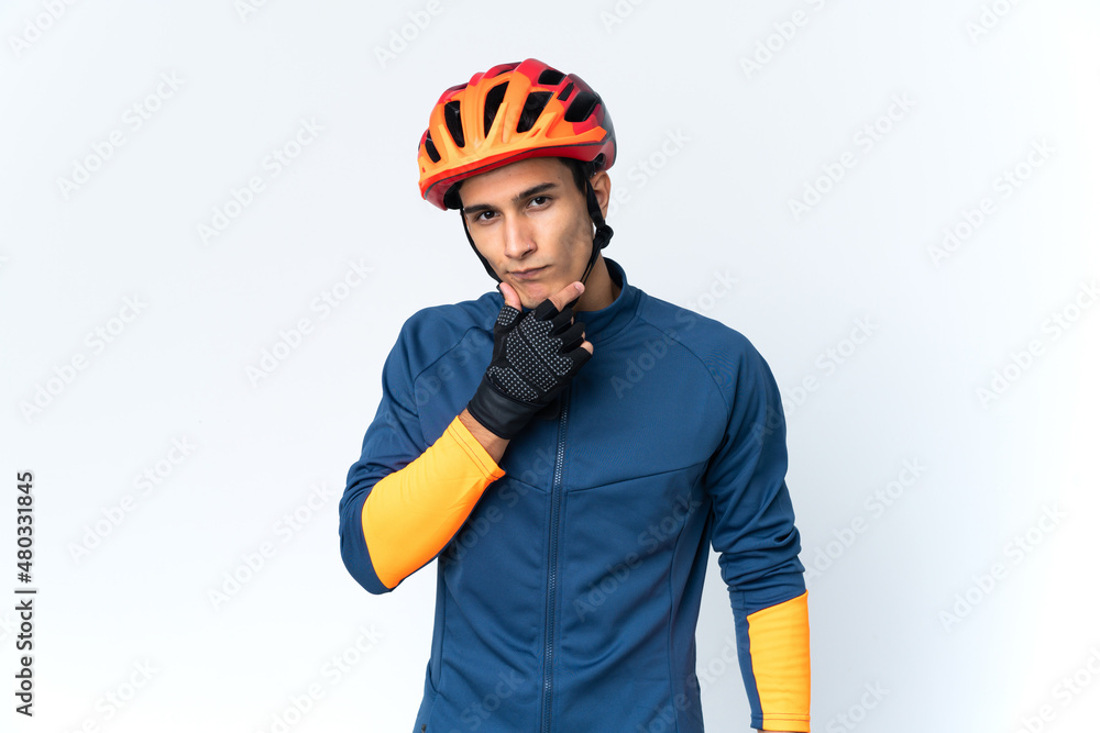 Fototapeta premium Young cyclist man isolated on background thinking