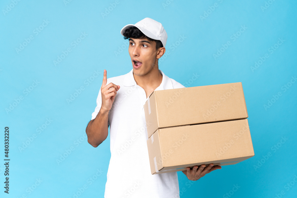 Delivery Argentinian man isolated on blue background thinking an idea pointing the finger up Delivery Argentinian man isolated on blue background thinking an idea pointing the finger up