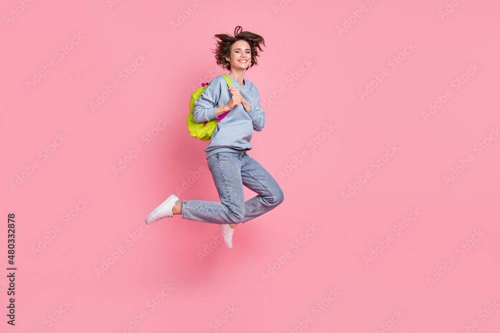 Full body photo of impressed young lady jump wear pullover jeans sneakers bag isolated on pink background