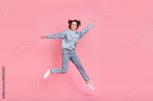 Full length photo of impressed young lady run wear pullover jeans shoes isolated on pink background