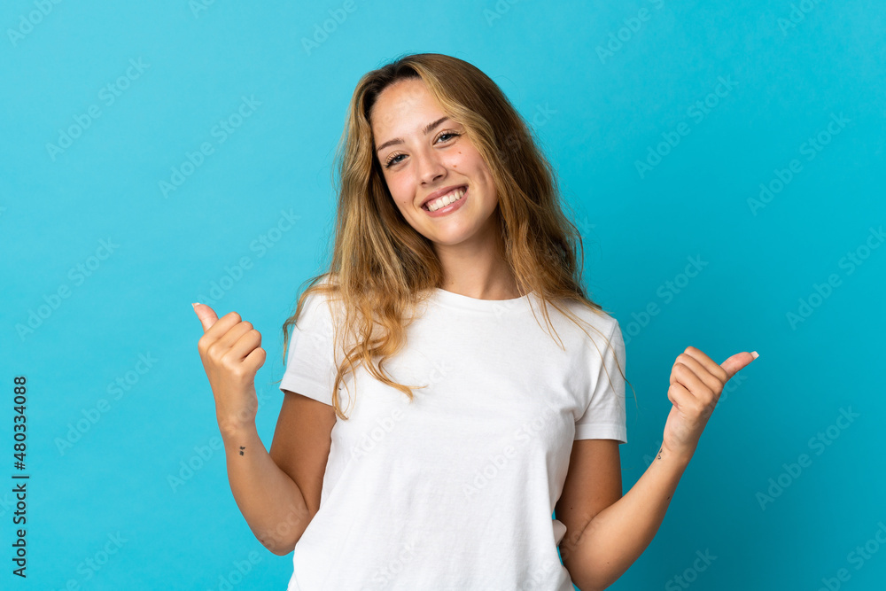 Fototapeta premium Young blonde woman isolated on blue background with thumbs up gesture and smiling