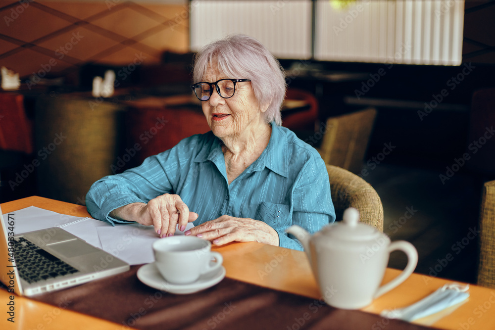 A businesswoman sitting in a cafe with a cup of coffee and a laptop Freelancer works unaltered A businesswoman sitting in a cafe with a cup of coffee and a laptop Freelancer works unaltered