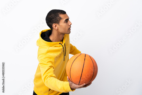 African American man over isolated white background playing basketball © luismolinero