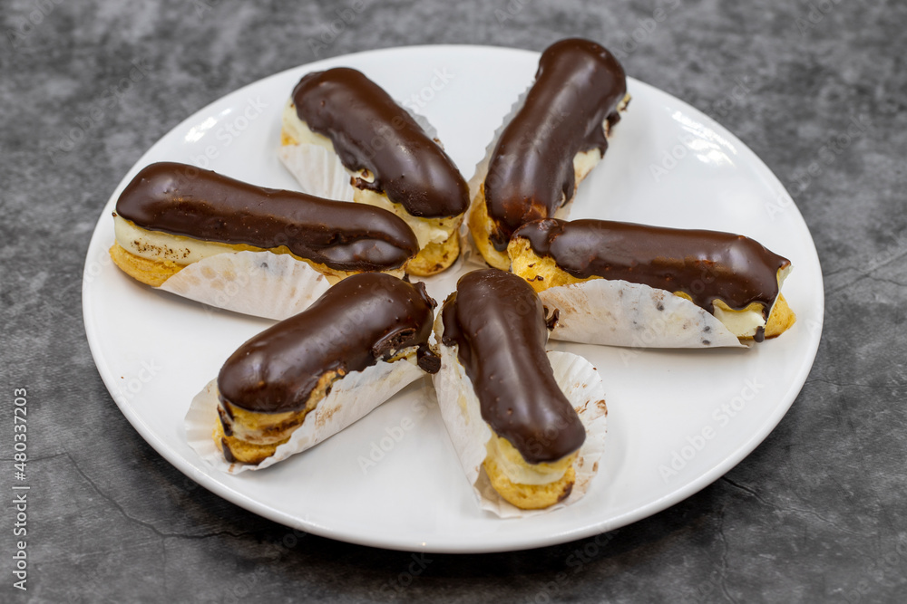 Chocolate eclair cake on dark background. Traditional french dessert. Pastry products. close up Chocolate eclair cake on dark background. Traditional french dessert. Pastry products. close up