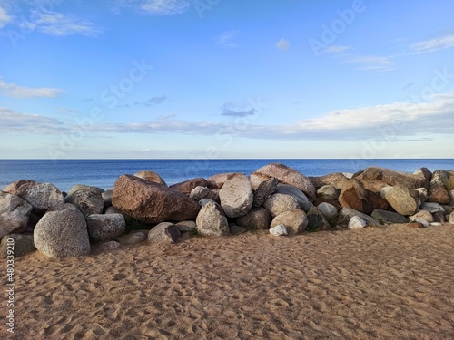 Stones on the shore of the lake. The smooth surface of the water of Lake Ladoga.