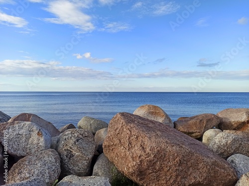 Stones on the shore of the lake. The smooth surface of the water of Lake Ladoga.