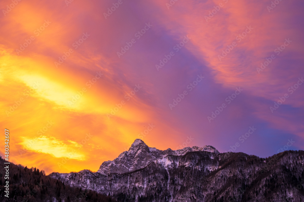Fototapeta premium Pink purple and orange sunrise sky over mountain peaks