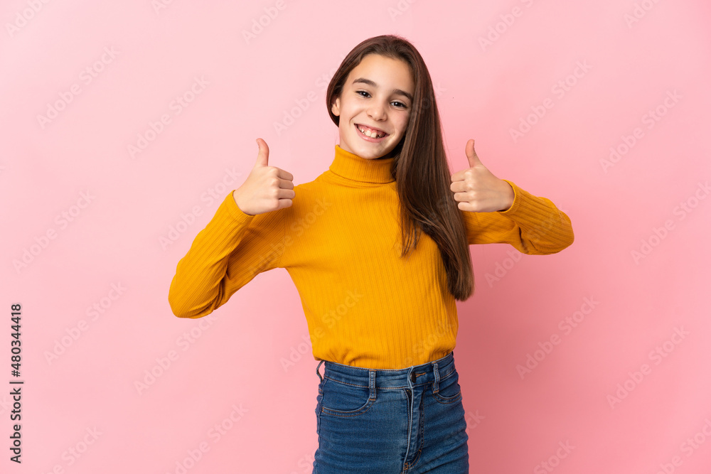 Little girl isolated on pink background giving a thumbs up gesture Little girl isolated on pink background giving a thumbs up gesture