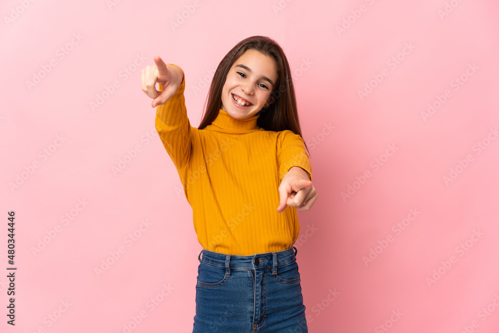 Little girl isolated on pink background pointing front with happy expression Little girl isolated on pink background pointing front with happy expression