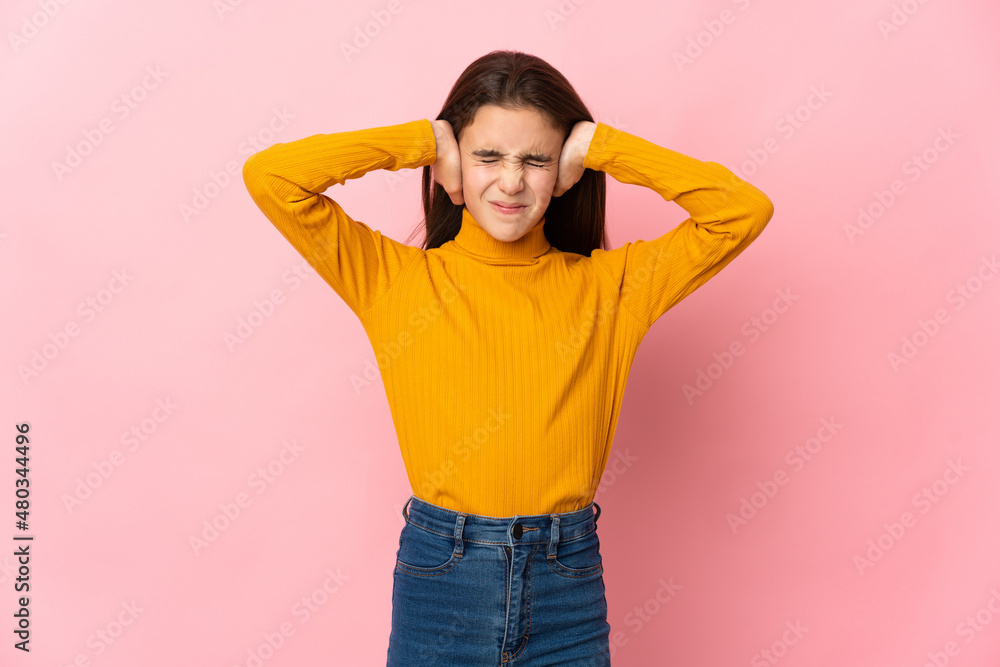 Little girl isolated on pink background frustrated and covering ears Little girl isolated on pink background frustrated and covering ears