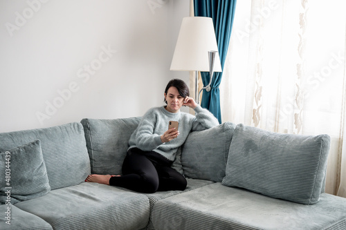 Young woman is resting on a sofa
