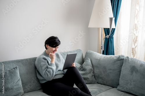 Young woman is resting on a sofa