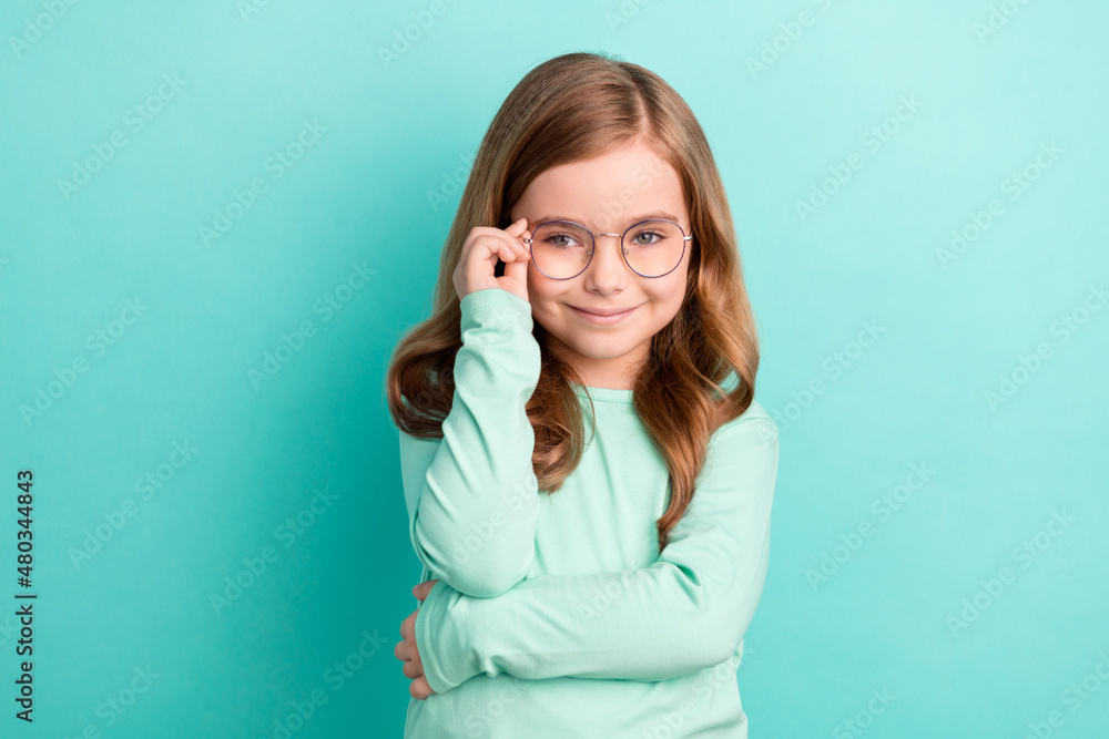 Photo of young attractive girl happy positive smile hand touch eyeglasses isolated over teal color background Photo of young attractive girl happy positive smile hand touch eyeglasses isolated over teal color background