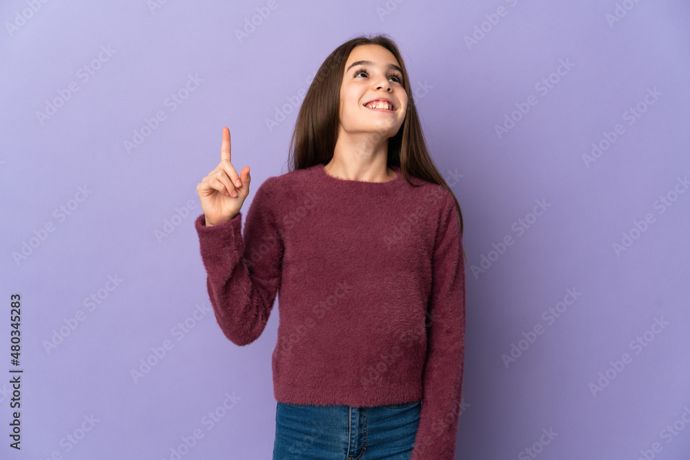 Little girl isolated on purple background pointing up and surprised Little girl isolated on purple background pointing up and surprised